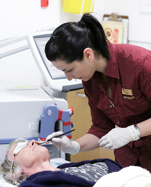 A registered nurse skillfully applies ALA cream for PDT to treat pre-cancerous skin spots